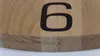 A close-up view of a wooden clock face with the number 6 prominently displayed. Náhled obrázku produktu