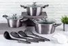 A set of cookware and kitchen utensils arranged on a surface with a brick-patterned background. Podgląd zdjęcia produktu