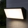 A modern outdoor wall light mounted on a brick wall at night. Produktbild-Vorschau