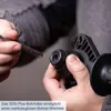 A close-up shot of a person's hands holding a drill bit and the chuck of a rotary hammer drill. Produktbild-Vorschau