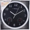 A black and white wall clock with a white frame, featuring a thermometer and hygrometer, is presented in its packaging. Produktbild-Vorschau