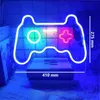 A neon sign shaped like a game controller is displayed in a room, with books underneath and a fuzzy rug. Produktbild-Vorschau