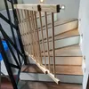 A wooden baby gate is installed on a staircase. Voir les images du produit