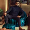 A man is sitting on a bean bag chair with a binary code pattern, with a small stool in front of him. The setting appears to be a modern living room or lounge area. Voir les images du produit