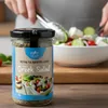 Physis of Crete Salatgewürz 50 g im Glas neben frischem griechischem Salat Produktbild-Vorschau