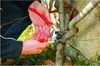 A person is pruning a tree branch with pruning shears. Náhled obrázku produktu