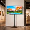A TV stand with a landscape image displayed on the screen, set up in what appears to be an art gallery or exhibition space. Anteprima dell’immagine prodotto
