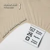 A close-up of a beige fabric with text and care symbols. Produktbild-Vorschau