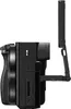 Side view of a black digital camera with its LCD screen flipped out and tilted upwards. Produktbild-Vorschau