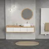 A modern bathroom with a wall-mounted vanity, a square sink, and a round mirror above it. A towel is hanging on a radiator to the right. Produktbild-Vorschau