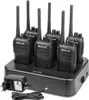 A set of six black Retevis RT21 walkie-talkies are neatly arranged in a black charging dock. A black power adapter with a coiled cord is plugged into the dock. Produktbild-Vorschau