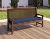 A wooden bench with a blue cushion is placed on a wooden deck outdoors. Produktbild-Vorschau