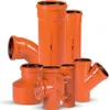 A collection of orange PVC pipes and fittings arranged on a white background. Náhľad obrázku produktu