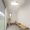 A hallway with a ceiling light, a plant, and a wooden bench. Voir les images du produit