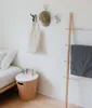 A bedroom scene with hooks on the wall, a bed, and a side table. Náhled obrázku produktu