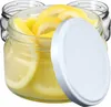 Several glass jars filled with lemon slices and liquid, with one white lid placed on top of a jar. Podgląd zdjęcia produktu