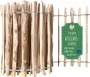 A roll of hazelnut fence made of wooden stakes bound together with wire, with a product tag attached.