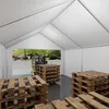 Inside a white tent structure, a yellow forklift is moving wooden pallets. Produktbild-Vorschau