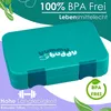 A teal lunchbox with the brand logo 'yummy buddy' printed on it, set against a light purple and teal background with green leaf graphics. Náhľad obrázku produktu