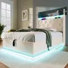 A modern bedroom with a white upholstered bed frame featuring LED lighting and a tufted headboard. The bed is made with white linens and a green throw blanket. Náhľad obrázku produktu