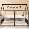 A black metal house-shaped bunk bed with two twin-sized mattresses, decorated with a banner that spells 'STARS' and a hanging monkey toy. Podgląd zdjęcia produktu