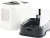 Two cat litter boxes are shown side-by-side against a white background. The one on the left is a fully enclosed litter box with a handle on top and a window on the side. The one on the right is an open litter box with a high back and a scoop attached to th Produktbild-Vorschau