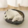 A white cat is sleeping comfortably in a grey cat bed with a scratching surface. Produktbild-Vorschau