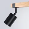 A black spotlight fixture is attached to a wooden beam. Podgląd zdjęcia produktu