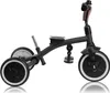 A black tricycle with beige handlebars is shown against a white background. Podgląd zdjęcia produktu