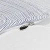 A close-up view of a zipper on a white and blue striped duvet cover. Produktbild-Vorschau