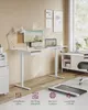 A modern home office setup featuring a white height-adjustable desk with a monitor, laptop, and a lamp. A treadmill is visible on the floor in the foreground. Produktbild-Vorschau