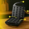 An open electric nut maker with multiple molds for baking nut-shaped cookies, placed on a wooden countertop with wooden cutting boards in the background. Voir les images du produit