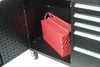 A red toolbox is placed on the shelf of a black rolling workbench. Produktbild-Vorschau