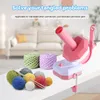 A yarn winder and several balls of yarn are displayed on a table, with a blurred background of a living room. Produktbild-Vorschau