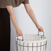 A person's hands are holding the handles of a laundry basket. Náhled obrázku produktu