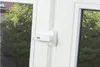 A close-up of a white window handle with a small electronic device attached. Produktbild-Vorschau