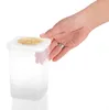 A hand is holding a clear plastic food storage container with a white lid. Produktbild-Vorschau