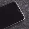 A close-up shot of the top corner of a smartphone with a black screen and silver edges, resting on a textured gray surface. Náhľad obrázku produktu