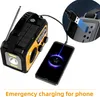A solar-powered emergency radio is shown charging a smartphone, with a close-up inset of the charging port. Náhled obrázku produktu