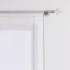 A close-up view of a window with sheer white curtains hanging from a silver curtain rod. The curtain rod has a decorative finial resembling tree branches. Produktbild-Vorschau