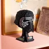 A LEGO Star Wars Kylo Ren helmet displayed on a stand on a shelf. Voir les images du produit