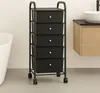 A black rolling storage cart with five drawers is shown in a bathroom setting next to a bathtub and a vanity. Produktbild-Vorschau
