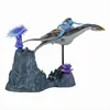 A toy figure of a Na'vi character riding a sea creature, displayed on a rocky, coral-like base with alien flora. Produktbild-Vorschau