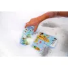 A child's hand is playing with bath puzzle pieces in a bubble bath. Produktbild-Vorschau