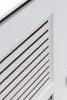 A close-up view of a white radiator cover with horizontal slats. Podgląd zdjęcia produktu