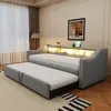 A grey upholstered daybed with a pull-out trundle bed is shown in a well-lit room with a large window and curtains. Produktbild-Vorschau