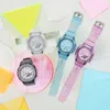 Four watches are arranged on a white surface with colorful geometric shapes. Voir les images du produit
