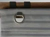 A close-up view of a roller blind with a metal ring and fabric with horizontal stripes, attached to a wooden rod with black clips. Produktbild-Vorschau