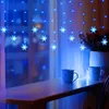 A window sill with two mugs and snowflake-shaped LED lights hanging in front of a window. Náhled obrázku produktu