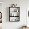 A black wall shelf with decorative items on it, mounted on a light-colored wall. Náhled obrázku produktu